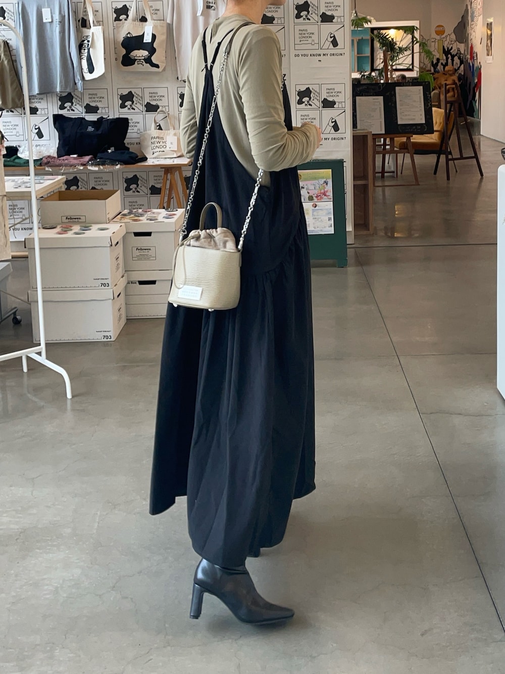 ベージュ系のショルダーバッグ、ブラック系のワンピース、ベージュ系のTシャツ/カットソーを着用したレディースの冬コーディネートの2枚目の写真