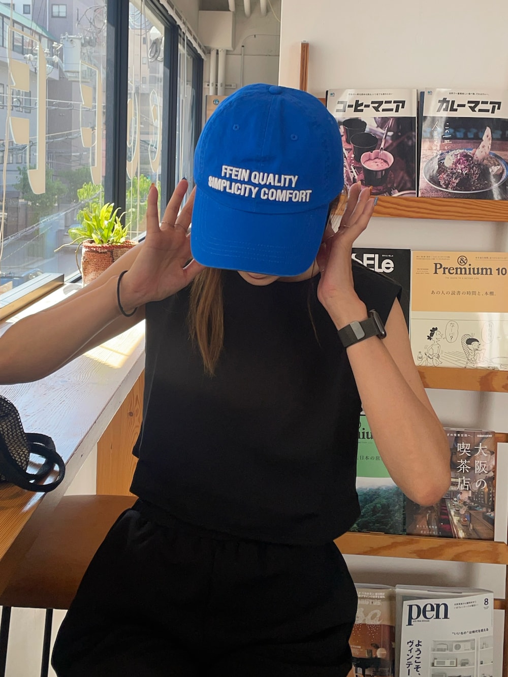 ブラック系のTシャツ/カットソー、ブルー系のキャップを着用したレディースの秋コーディネートの2枚目の写真