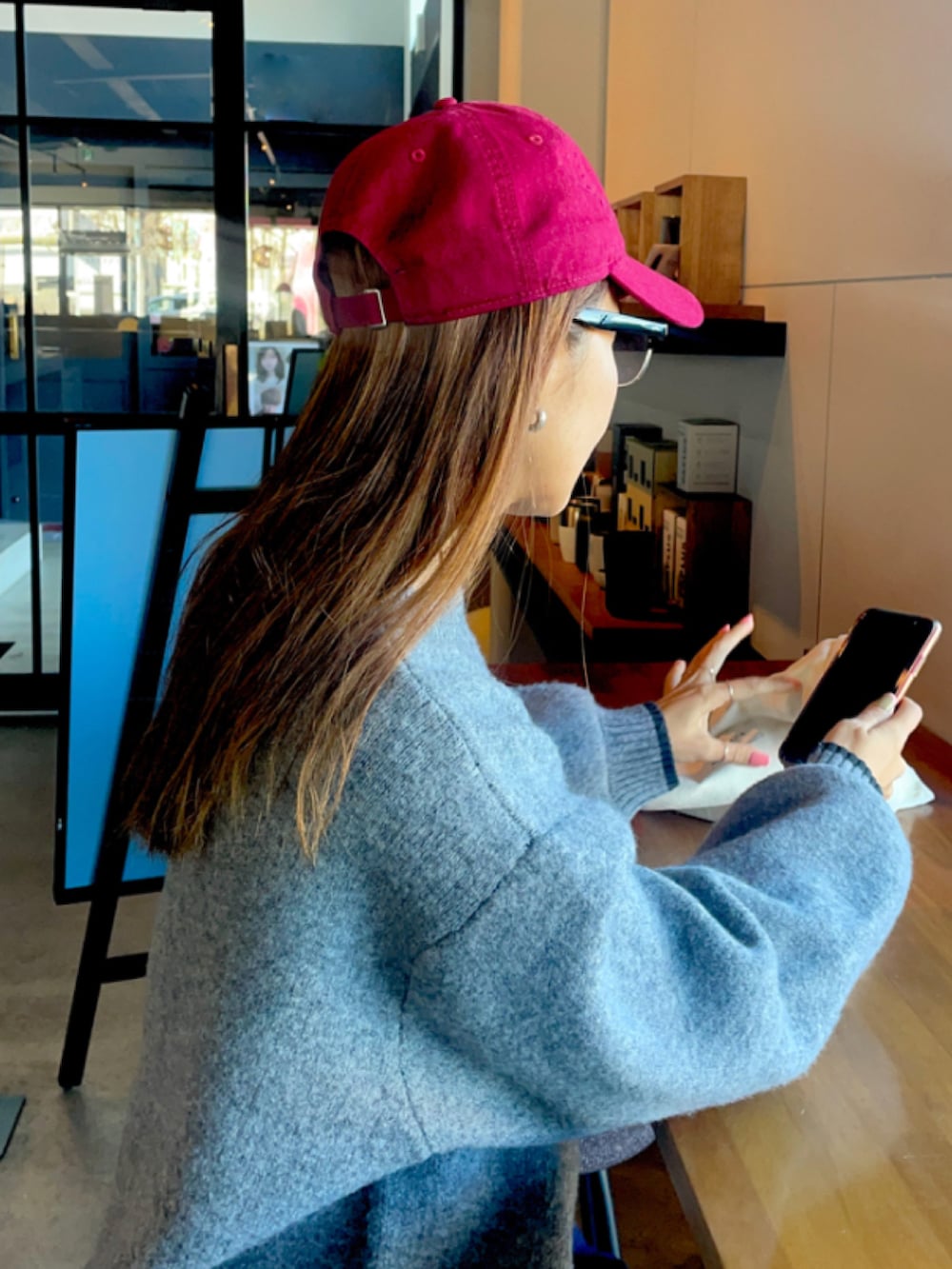 グレー系のニット/セーター、レッド系のキャップを着用したレディースの冬コーディネートの3枚目の写真