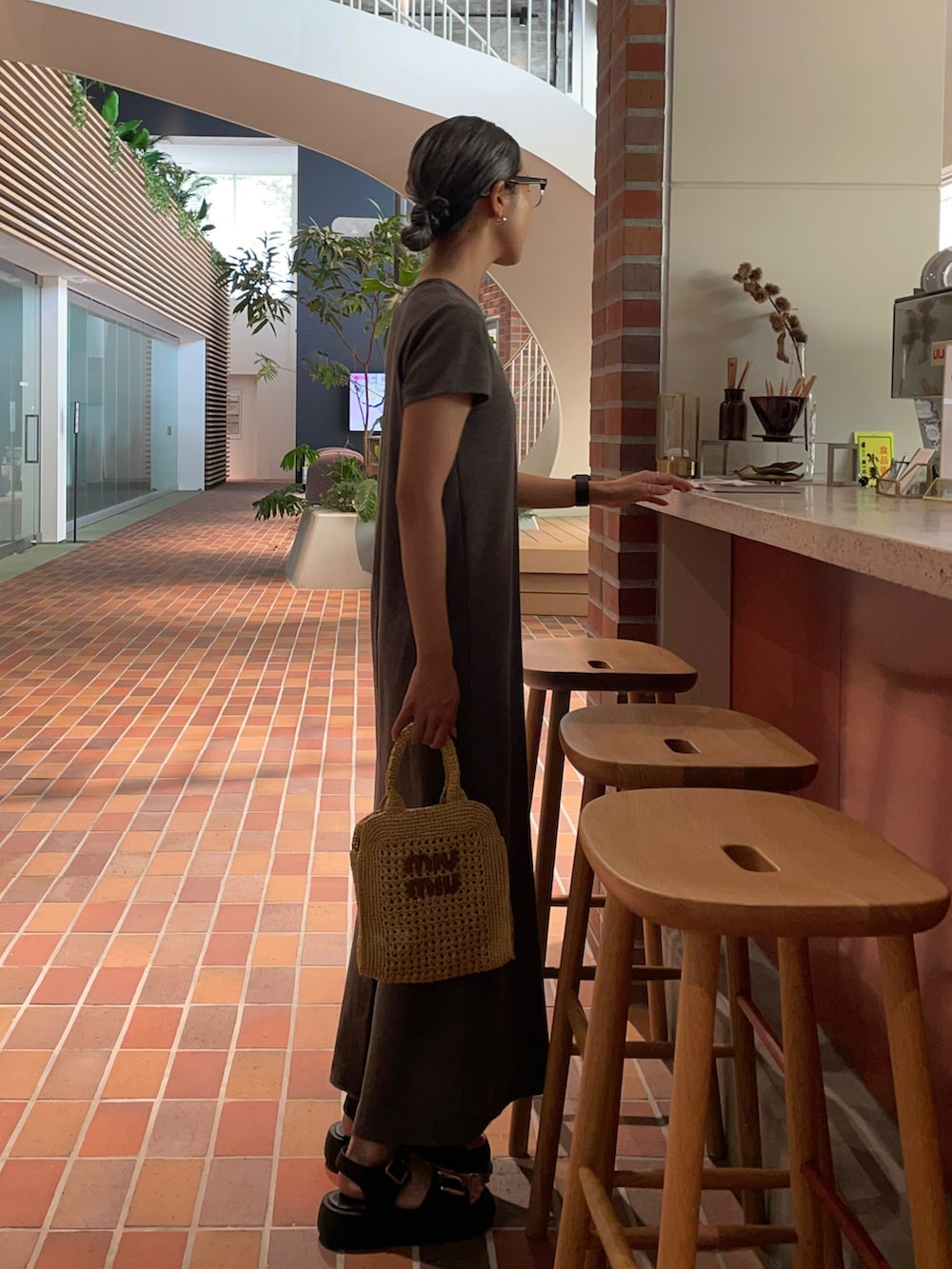 グレー系のワンピース、ブラウン系のバッグを着用したレディースの夏コーディネートの3枚目の写真