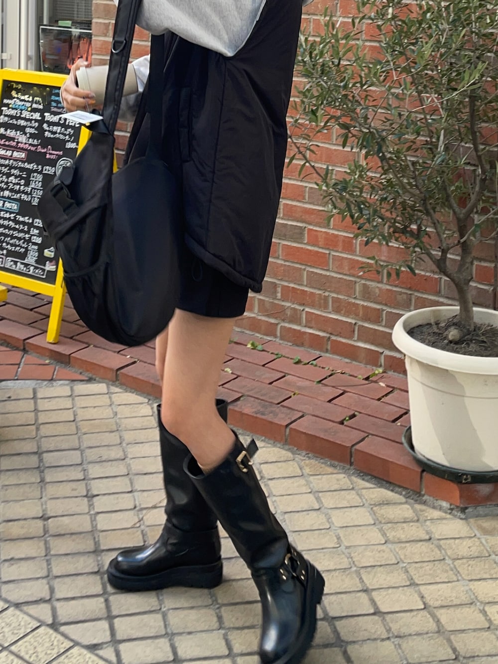 ブラック系のブーツ、ブラック系のボディバッグ/ウエストポーチを着用したレディースの冬コーディネートの2枚目の写真