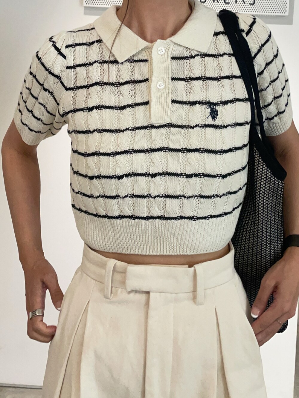 ホワイト系のその他パンツ、ブラック系のサンダル、ホワイト系のポロシャツを着用したレディースの春コーディネートの2枚目の写真