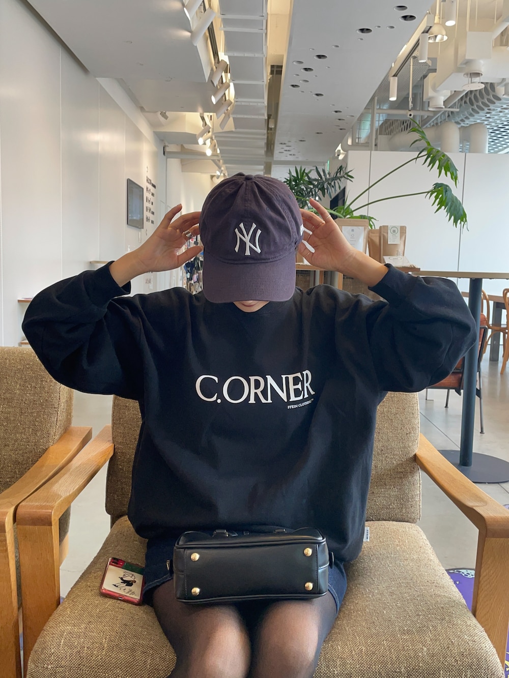 ブラック系のスウェット、ブルー系のキャップを着用したレディースの秋コーディネートの3枚目の写真