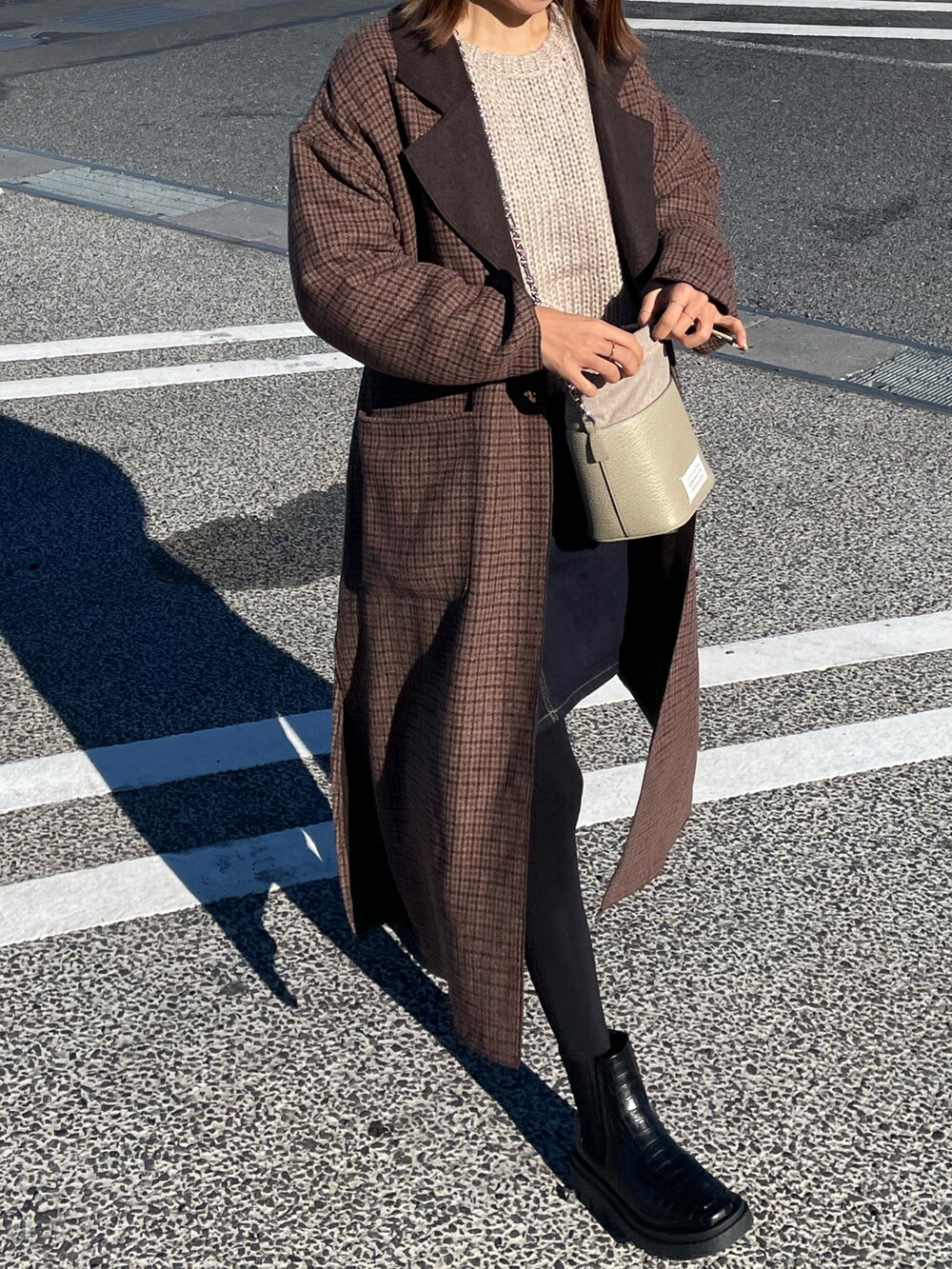 ブルー系のデニムスカート、ベージュ系のバッグ、ベージュ系のニット/セーターを着用したレディースの冬コーディネートの2枚目の写真