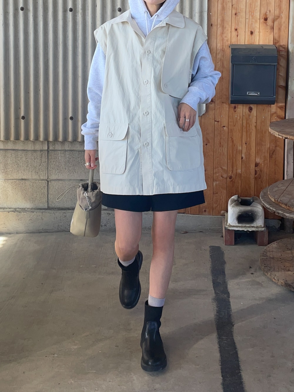 ブラック系のブーツ、ホワイト系のブルゾン、ブラック系のショルダーバッグを着用したレディースの冬コーディネートの3枚目の写真