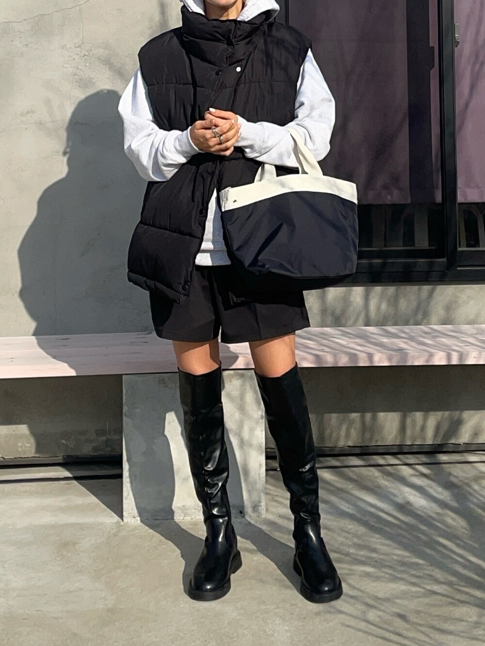 ブラック系のトートバッグを着用したレディースの冬コーディネートの2枚目の写真