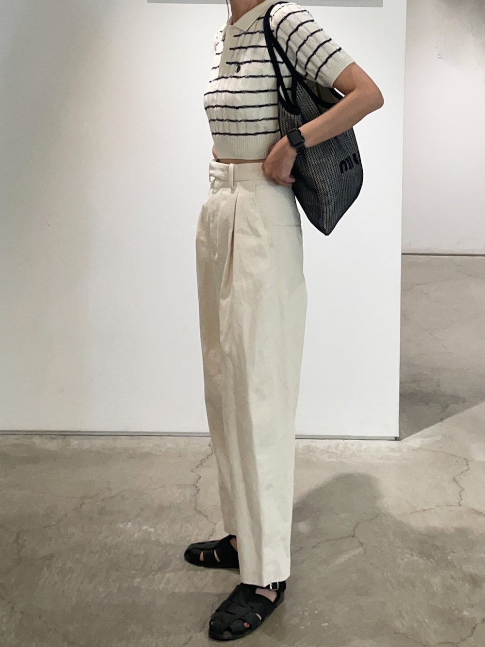 ホワイト系のその他パンツ、ブラック系のサンダル、ホワイト系のポロシャツを着用したレディースの春コーディネートの3枚目の写真