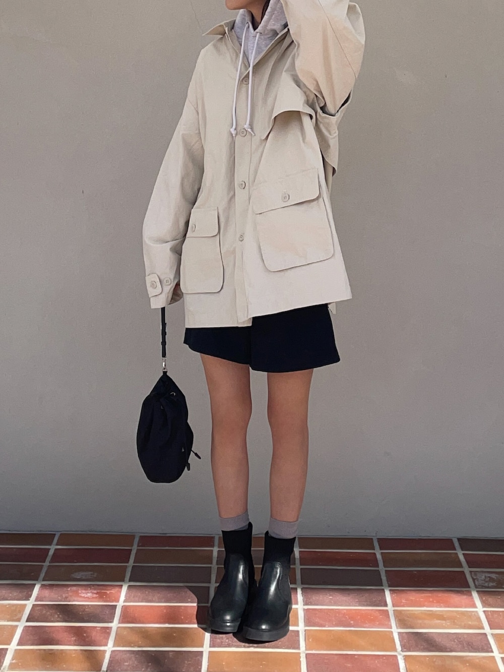 ブラック系のブーツ、ホワイト系のブルゾン、ブラック系のショルダーバッグを着用したレディースの冬コーディネートの2枚目の写真