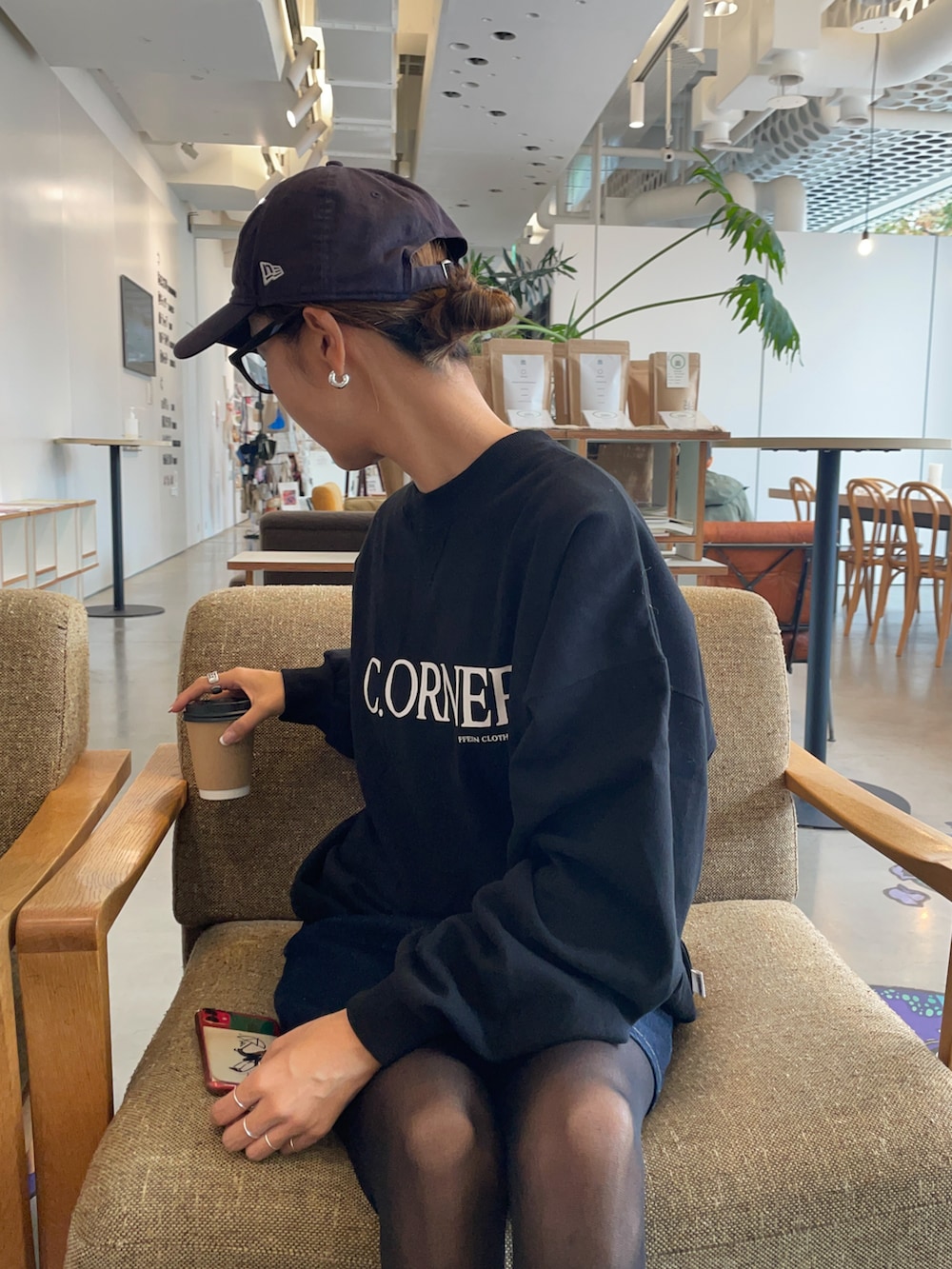 ブラック系のスウェット、ブルー系のキャップを着用したレディースの秋コーディネートの2枚目の写真