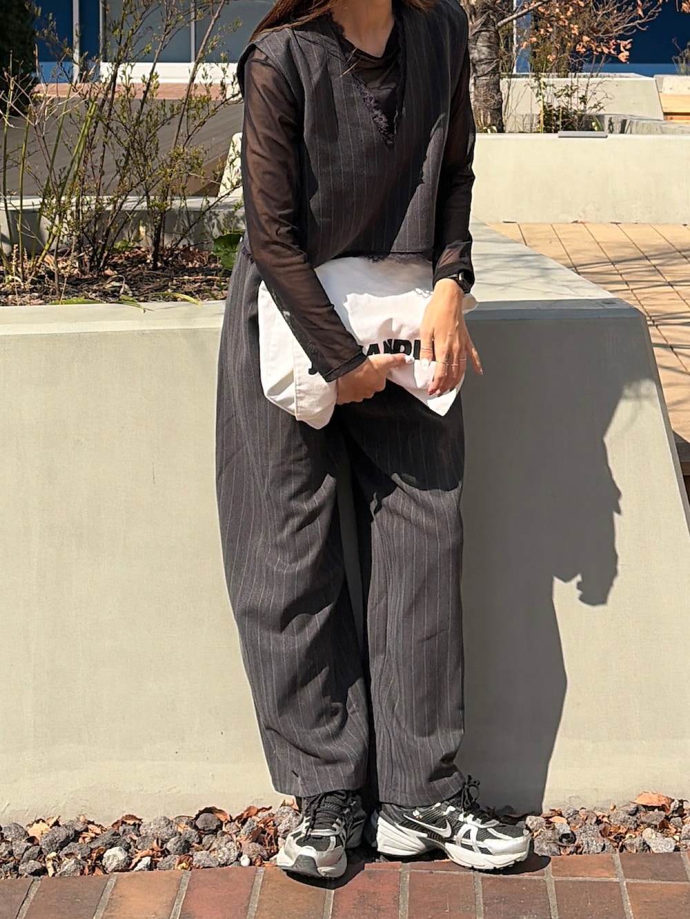 グレー系のベスト、グレー系のスラックスを着用したレディースの春コーディネートの2枚目の写真