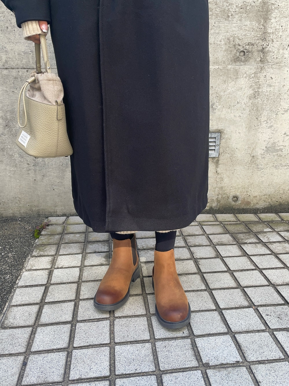 ベージュ系のショルダーバッグ、ブラック系のダッフルコート、ブラウン系のブーツを着用したレディースの秋コーディネートの3枚目の写真