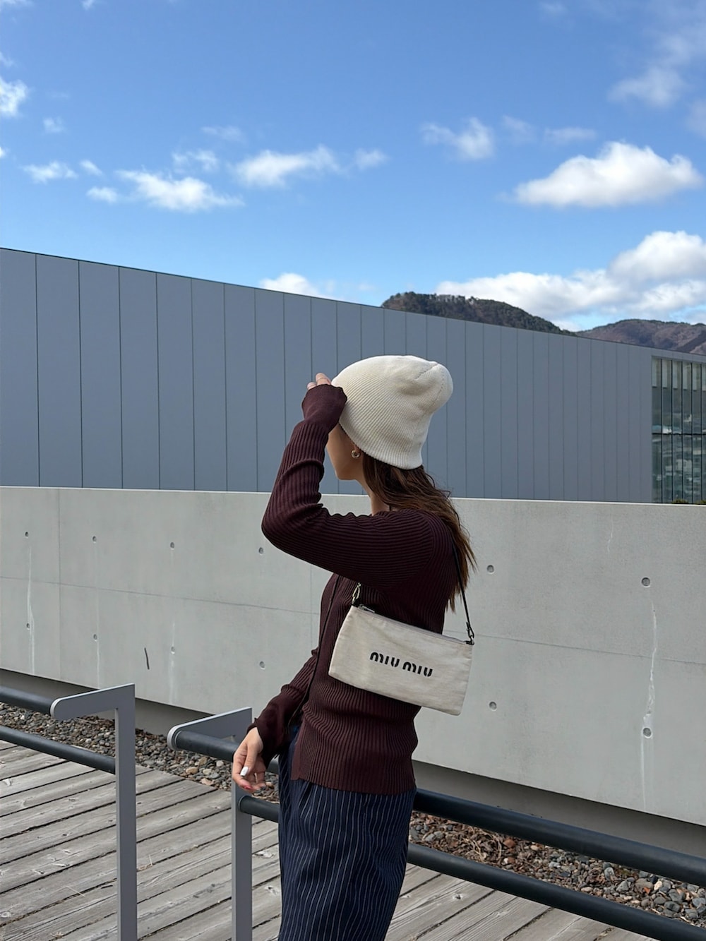 ブラウン系のカーディガン/ボレロ、ホワイト系のニットキャップ/ビーニーを着用したレディースの春コーディネートの3枚目の写真