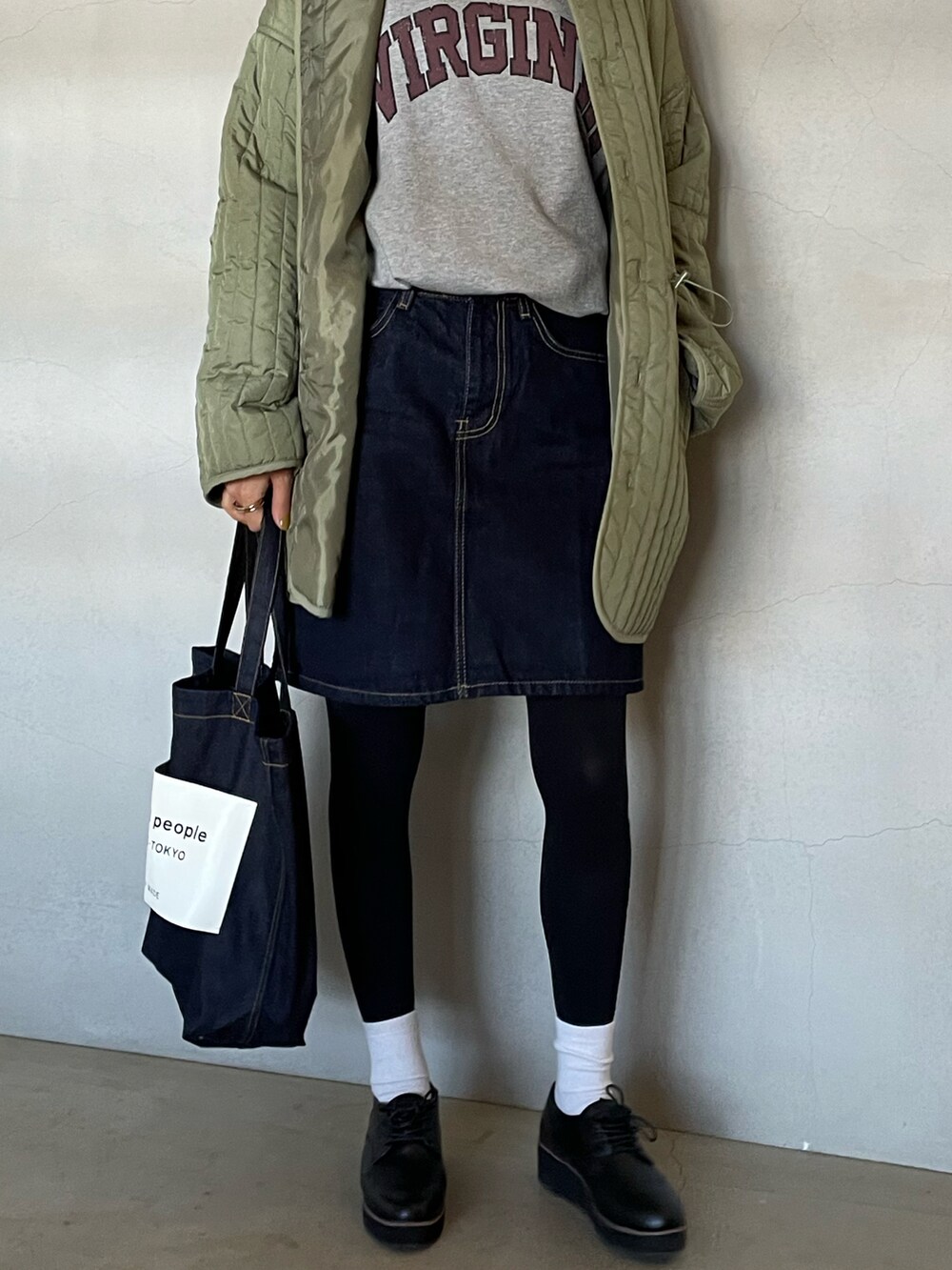 グリーン系のモッズコート、グレー系のスウェット、ブルー系のデニムスカートを着用したレディースの秋コーディネートの2枚目の写真