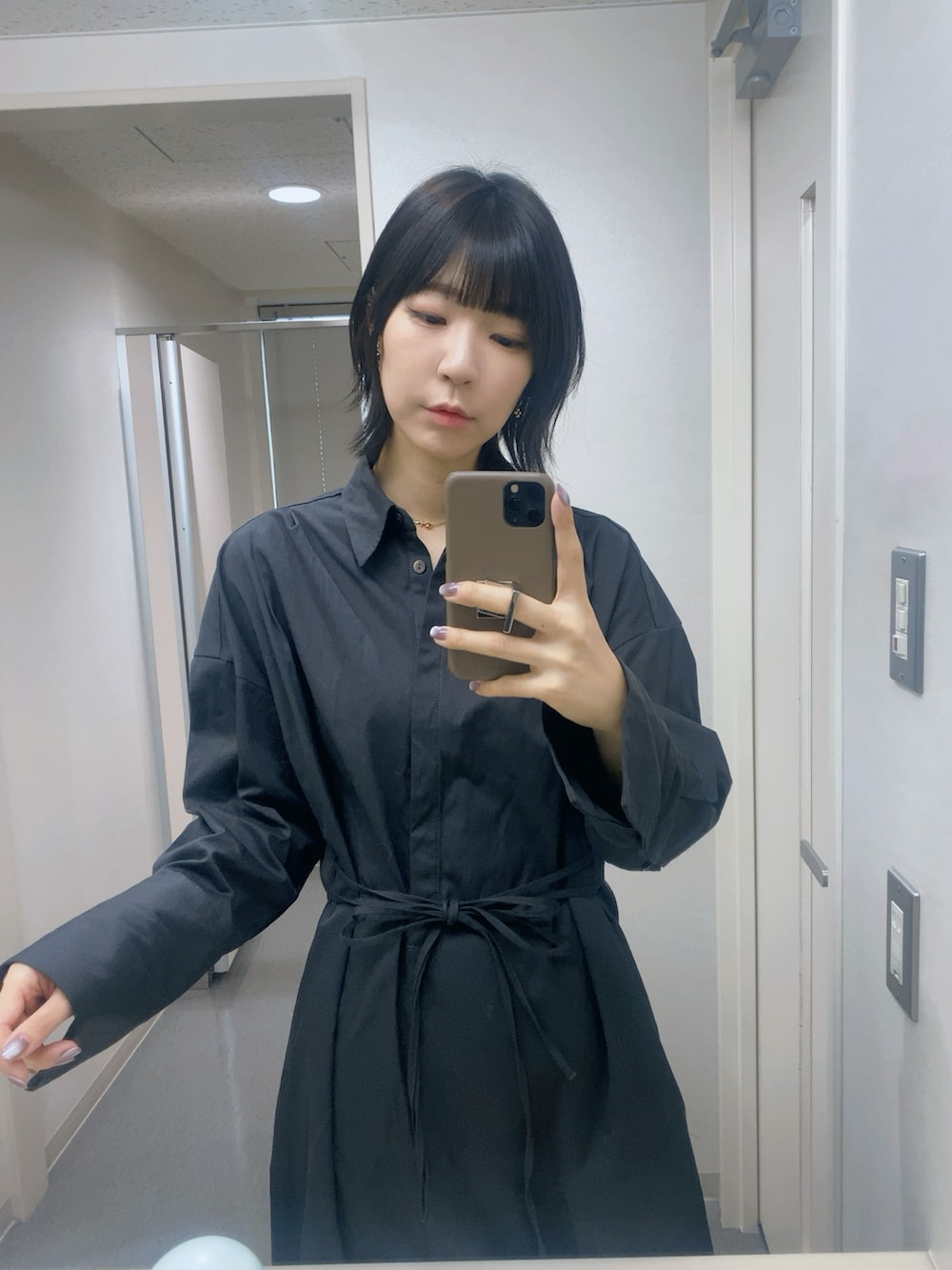 ブラック系のスラックス、ブラック系のワンピース、ブラック系のスニーカーを着用したレディースの秋コーディネートの2枚目の写真