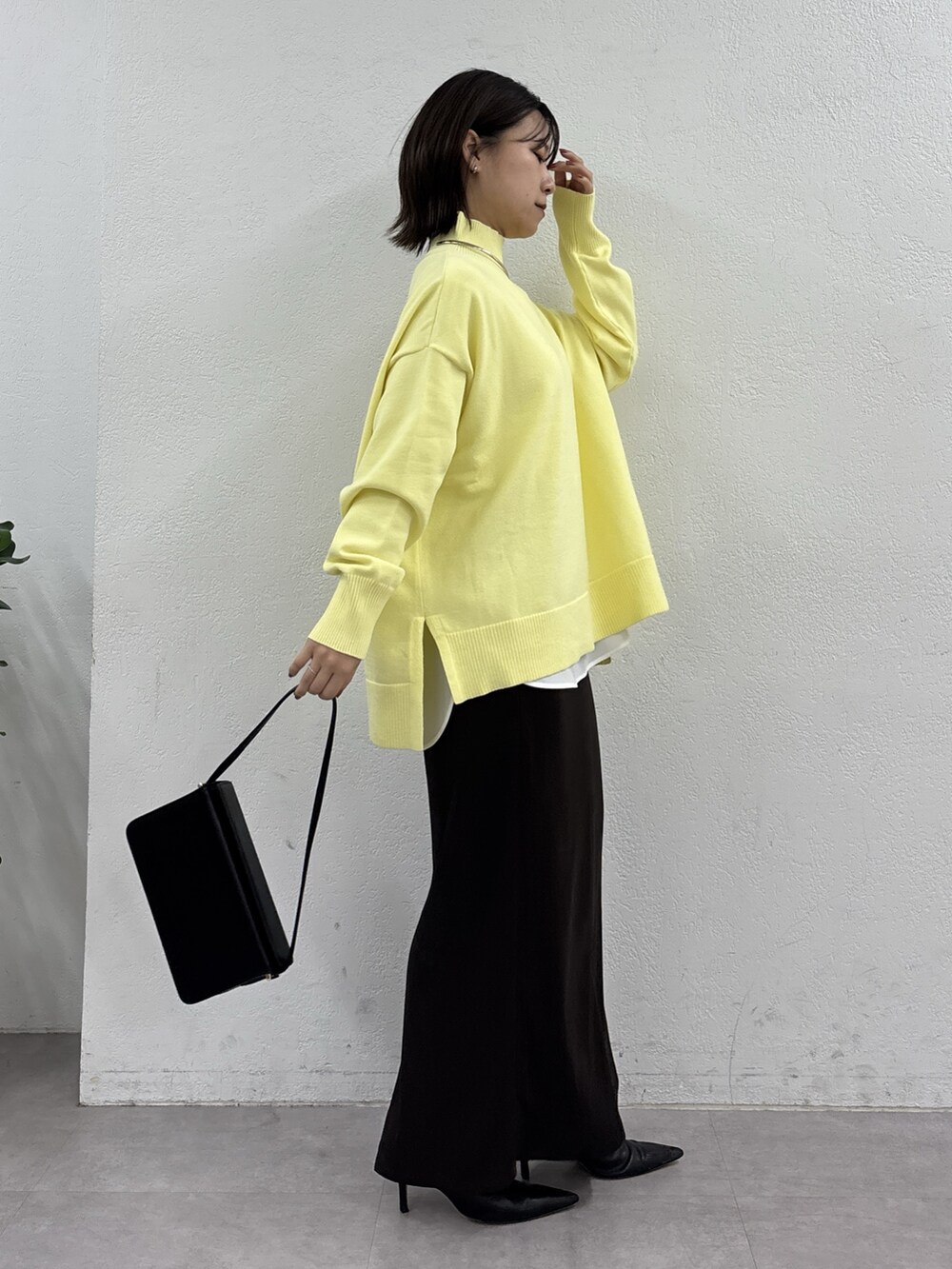 イエロー系のニット/セーター、ホワイト系のシャツ/ブラウス、ブラウン系のスカートを着用したレディースの秋コーディネートの4枚目の写真