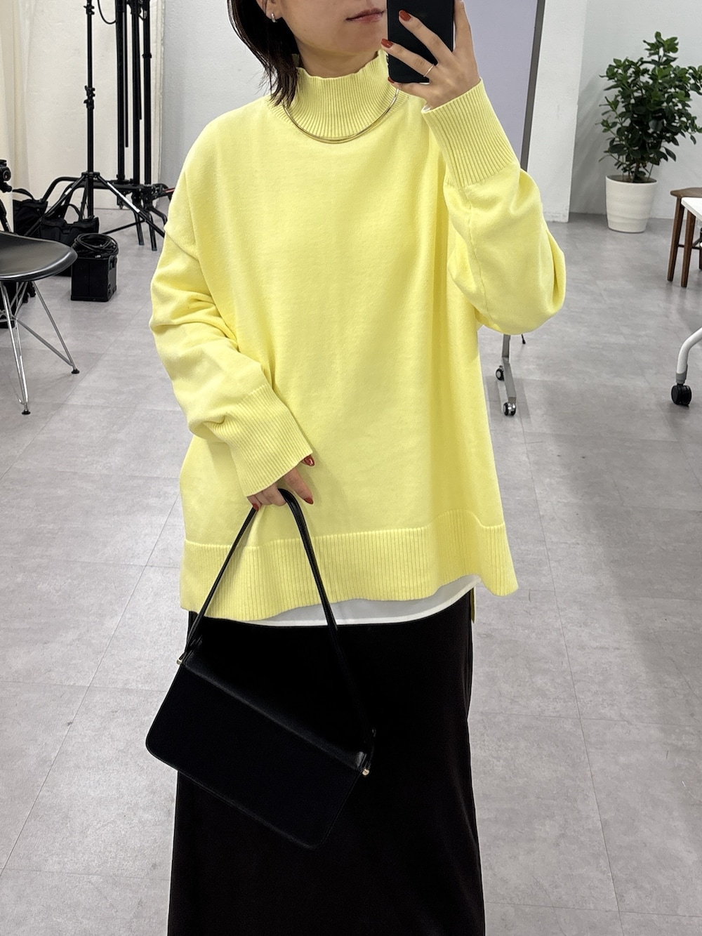 イエロー系のニット/セーター、ホワイト系のシャツ/ブラウス、ブラウン系のスカートを着用したレディースの秋コーディネートの5枚目の写真