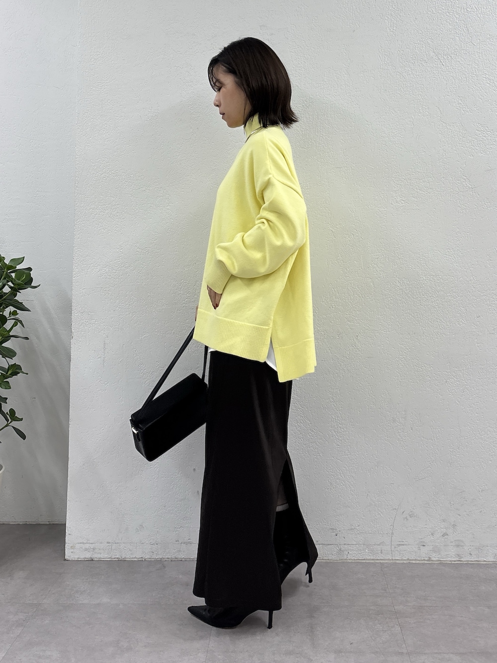 イエロー系のニット/セーター、ホワイト系のシャツ/ブラウス、ブラウン系のスカートを着用したレディースの秋コーディネートの2枚目の写真