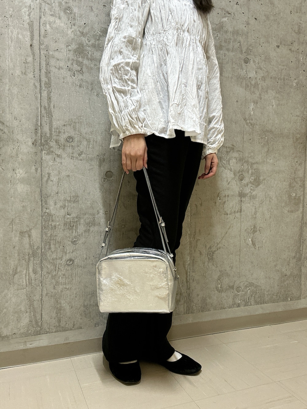 シルバー系のトートバッグを着用したレディースの冬コーディネートの4枚目の写真