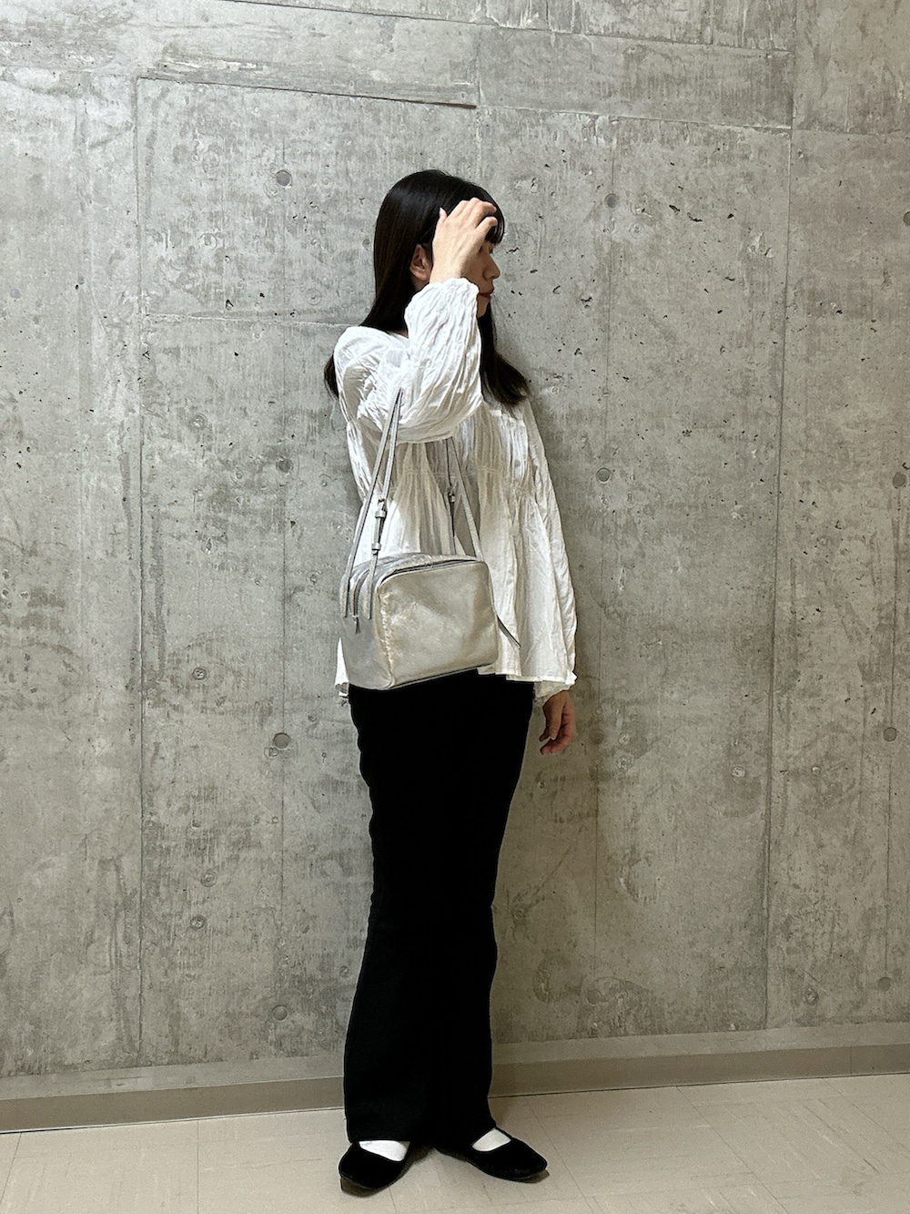 シルバー系のトートバッグを着用したレディースの冬コーディネートの2枚目の写真