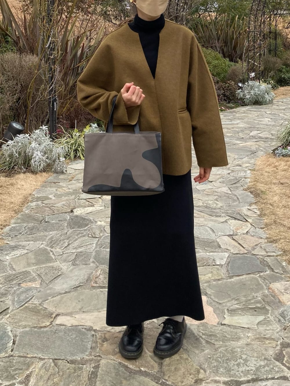 グリーン系のTシャツ/カットソー、ブラック系のワンピース、ブラック系のドレスシューズを着用したレディースの春コーディネートの2枚目の写真