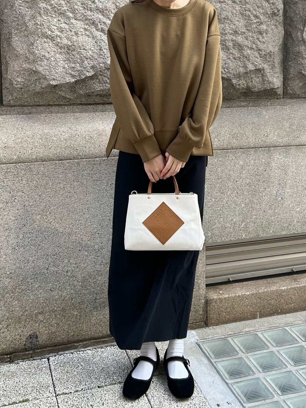 グリーン系のスウェット、ブラック系のワンピース、ホワイト系のトートバッグを着用したレディースの春コーディネートの3枚目の写真