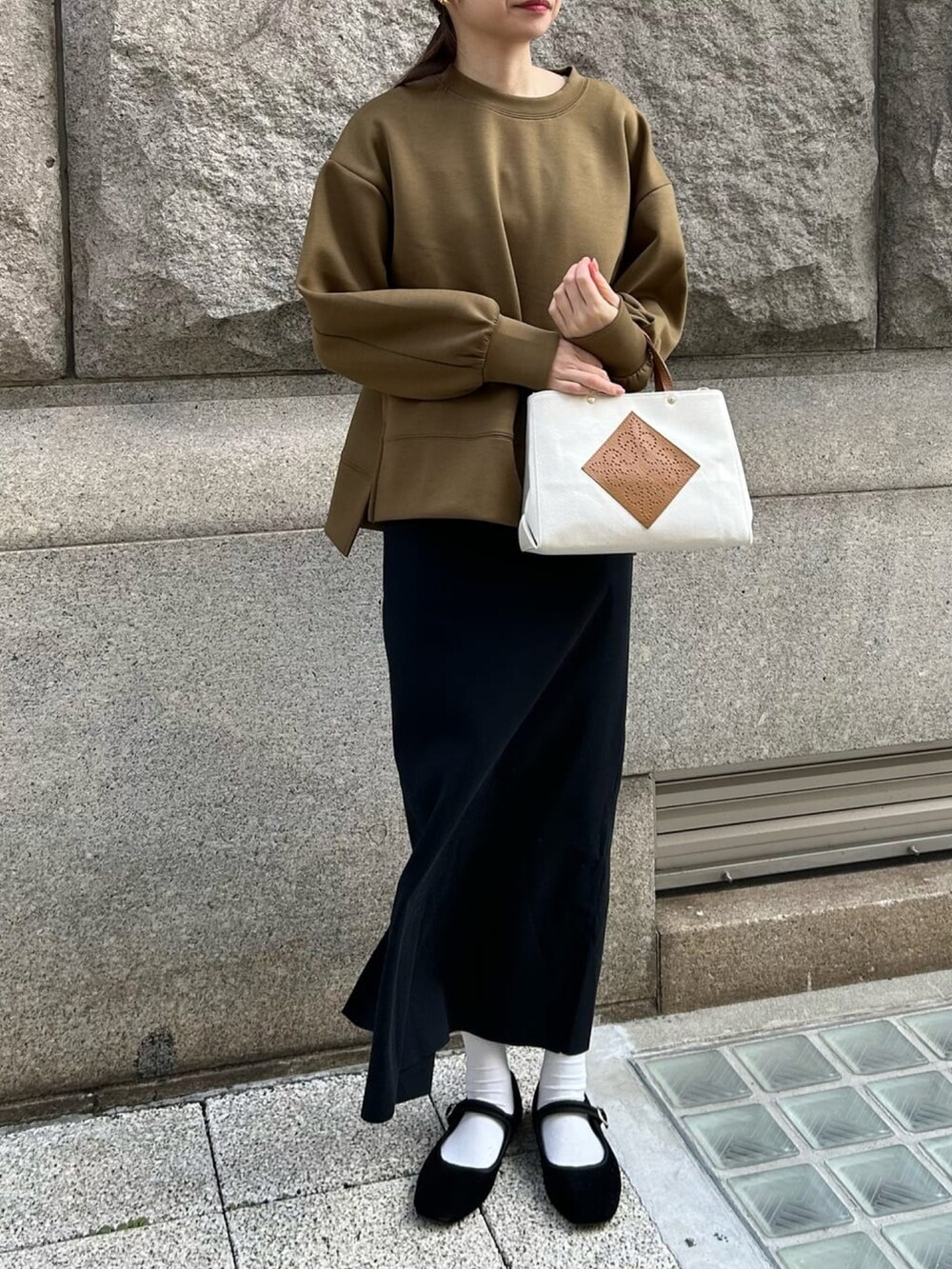 グリーン系のスウェット、ブラック系のワンピース、ホワイト系のトートバッグを着用したレディースの春コーディネートの2枚目の写真