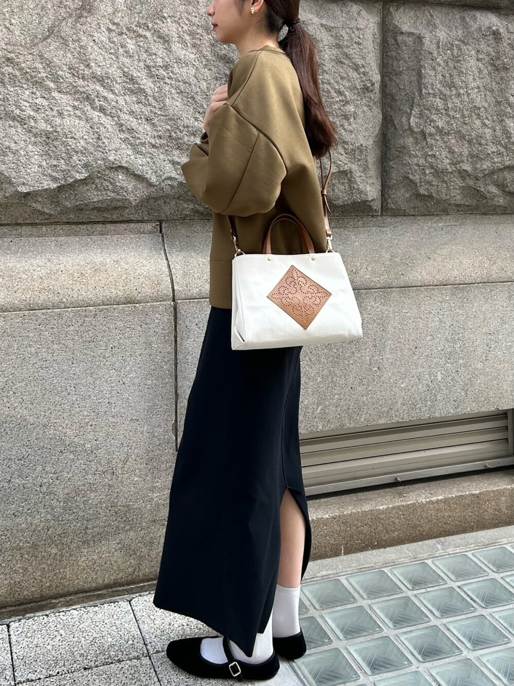 グリーン系のスウェット、ブラック系のワンピース、ホワイト系のトートバッグを着用したレディースの春コーディネートの4枚目の写真