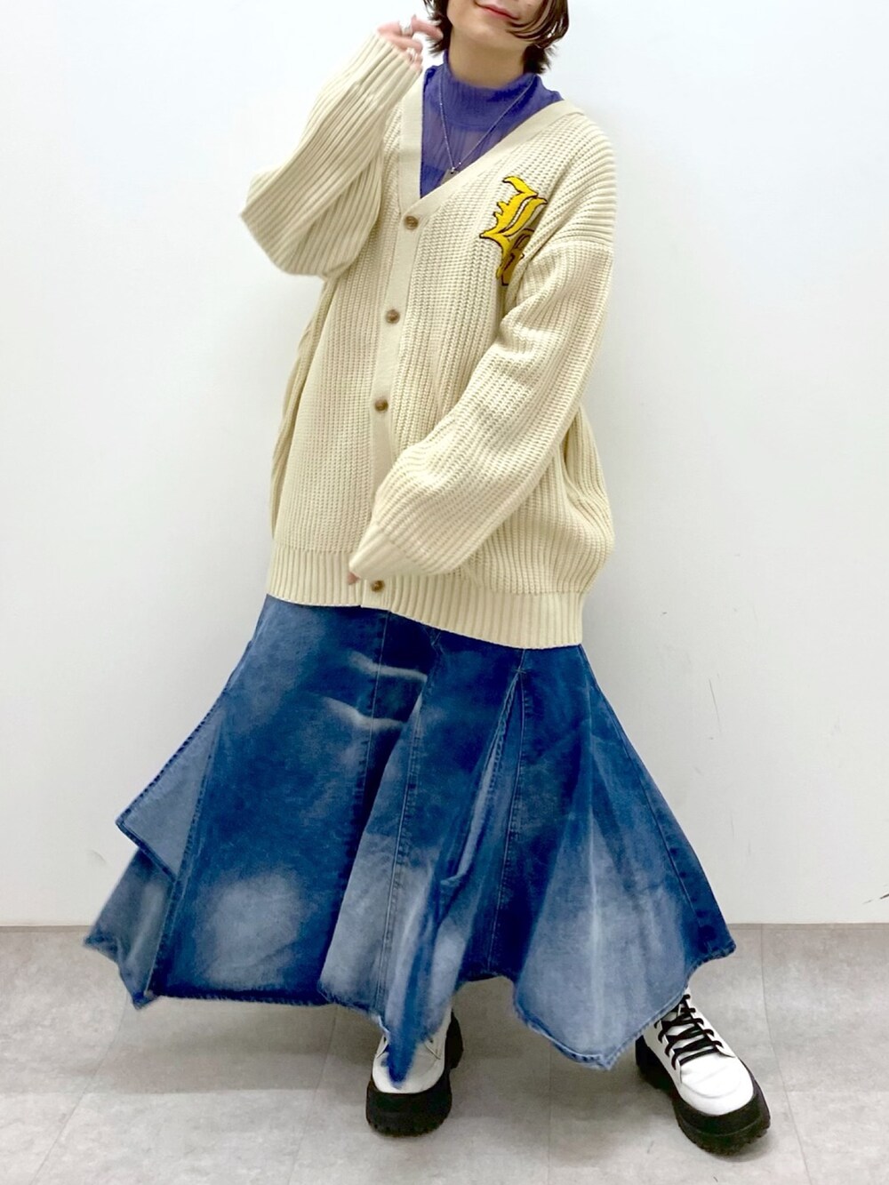 ブルー系のスカート、ホワイト系のトップス、パープル系のトップスを着用したレディースの春コーディネートの4枚目の写真