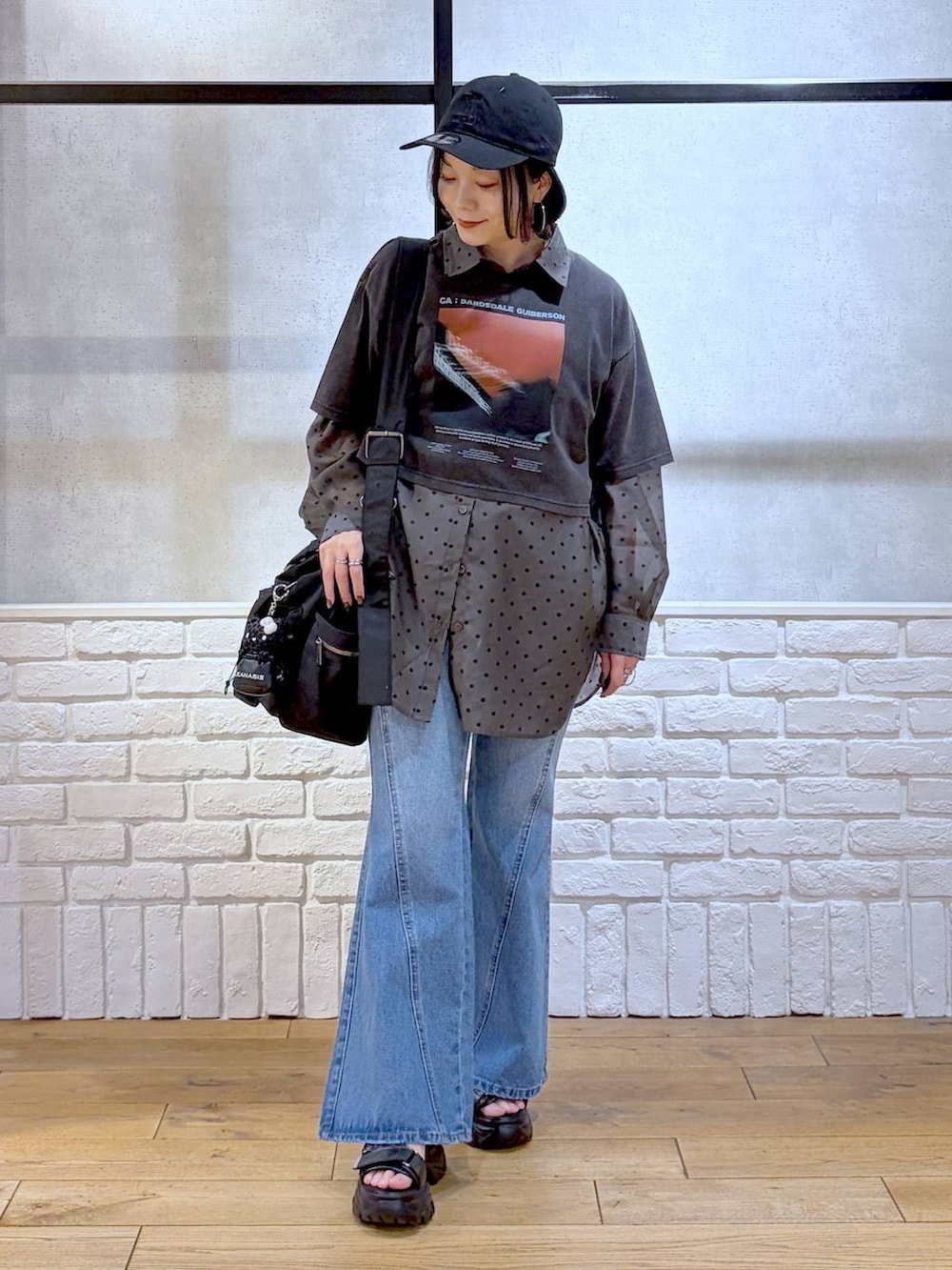 ブルー系のデニムパンツ、ブラック系のボストンバッグ、ブラック系のサンダルを着用したレディースの春コーディネートの9枚目の写真