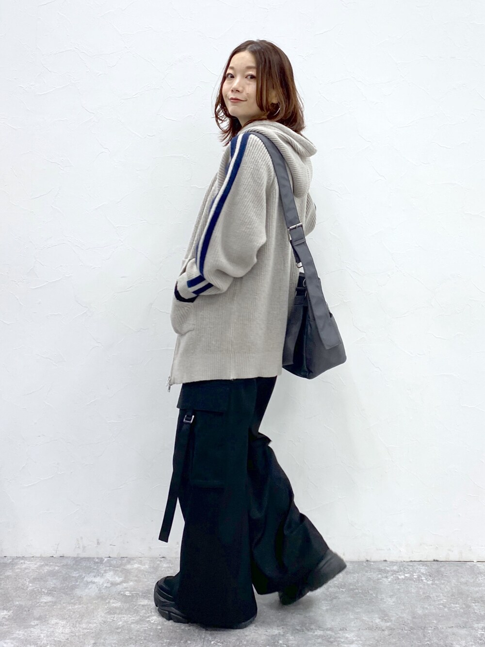 グレー系のニット/セーター、ブラック系のTシャツ/カットソー、ブラック系のスラックスを着用したレディースの秋コーディネートの7枚目の写真