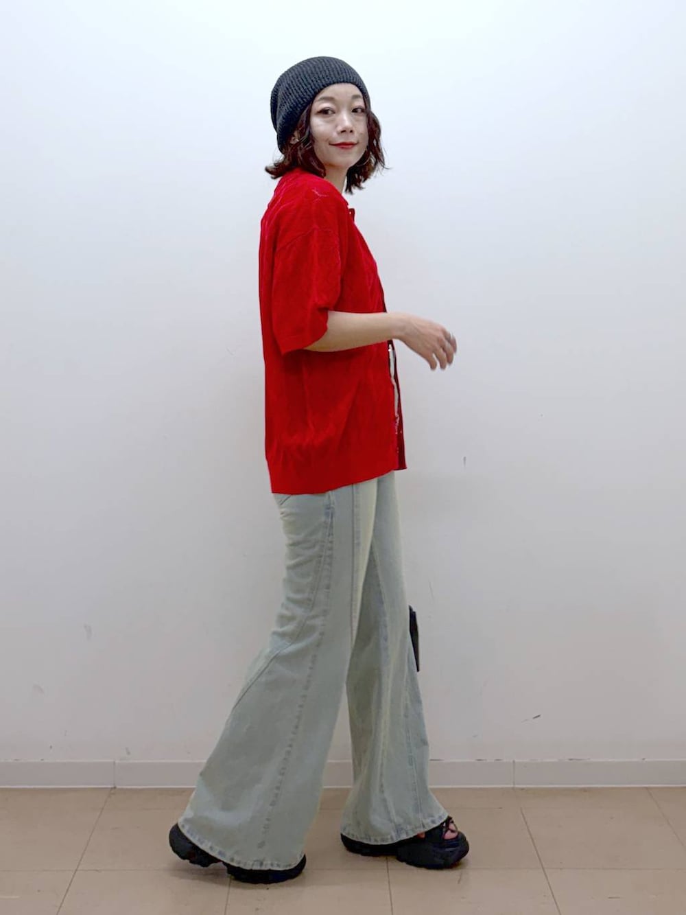 レッド系のポロシャツ、ブルー系のデニムパンツ、ブラック系のサンダルを着用したレディースの夏コーディネートの7枚目の写真