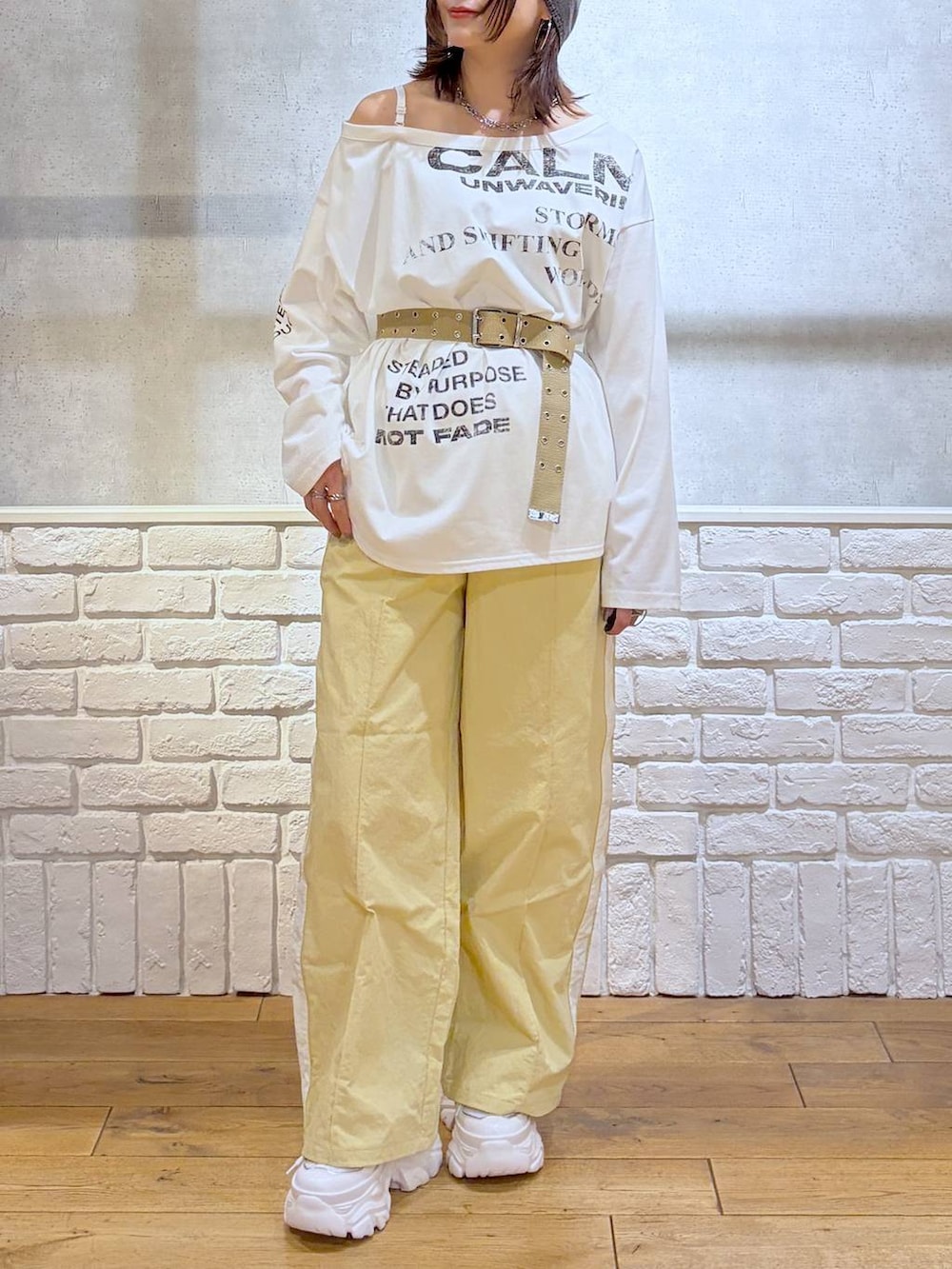 ホワイト系のスニーカー、イエロー系のスウェットパンツ、ホワイト系のTシャツ/カットソーを着用したレディースの春コーディネートの3枚目の写真