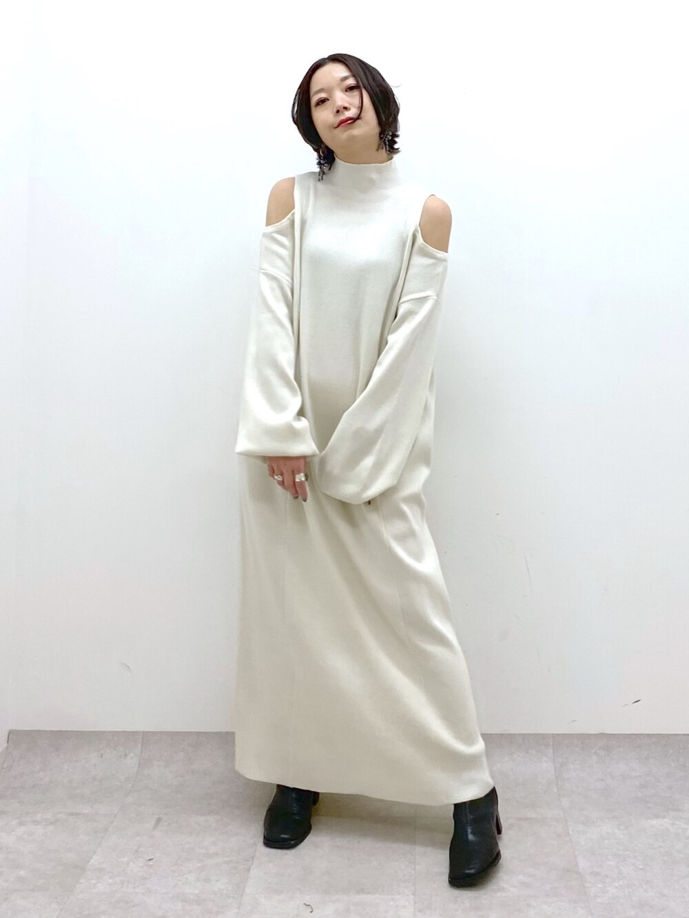 ホワイト系のワンピース、ホワイト系のボディバッグ/ウエストポーチ、ブラック系のTシャツ/カットソーを着用したレディースの冬コーディネートの2枚目の写真