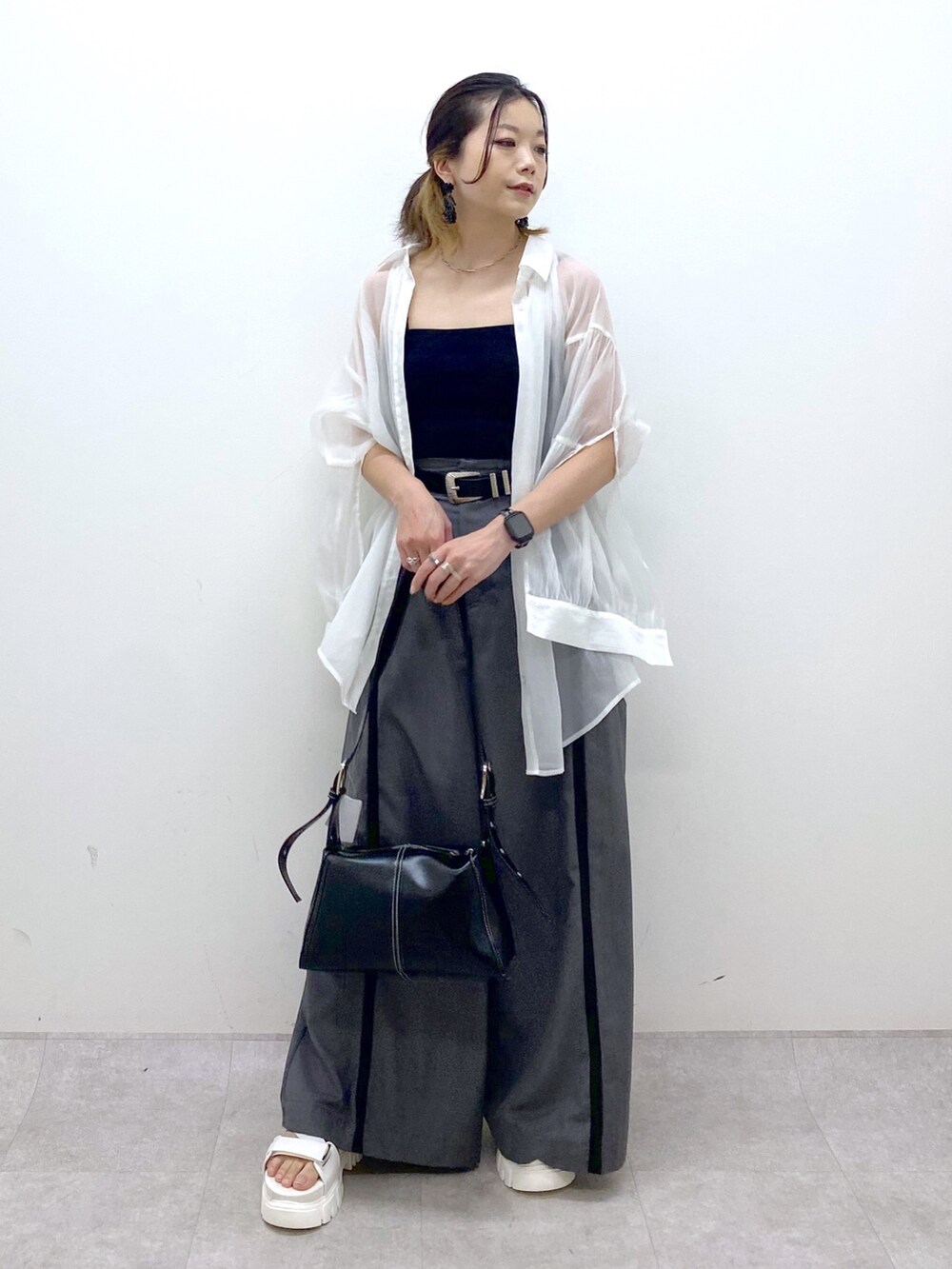 グレー系のスラックス、ブラック系のキャミソール、ブラック系のショルダーバッグを着用したレディースの夏コーディネートの3枚目の写真