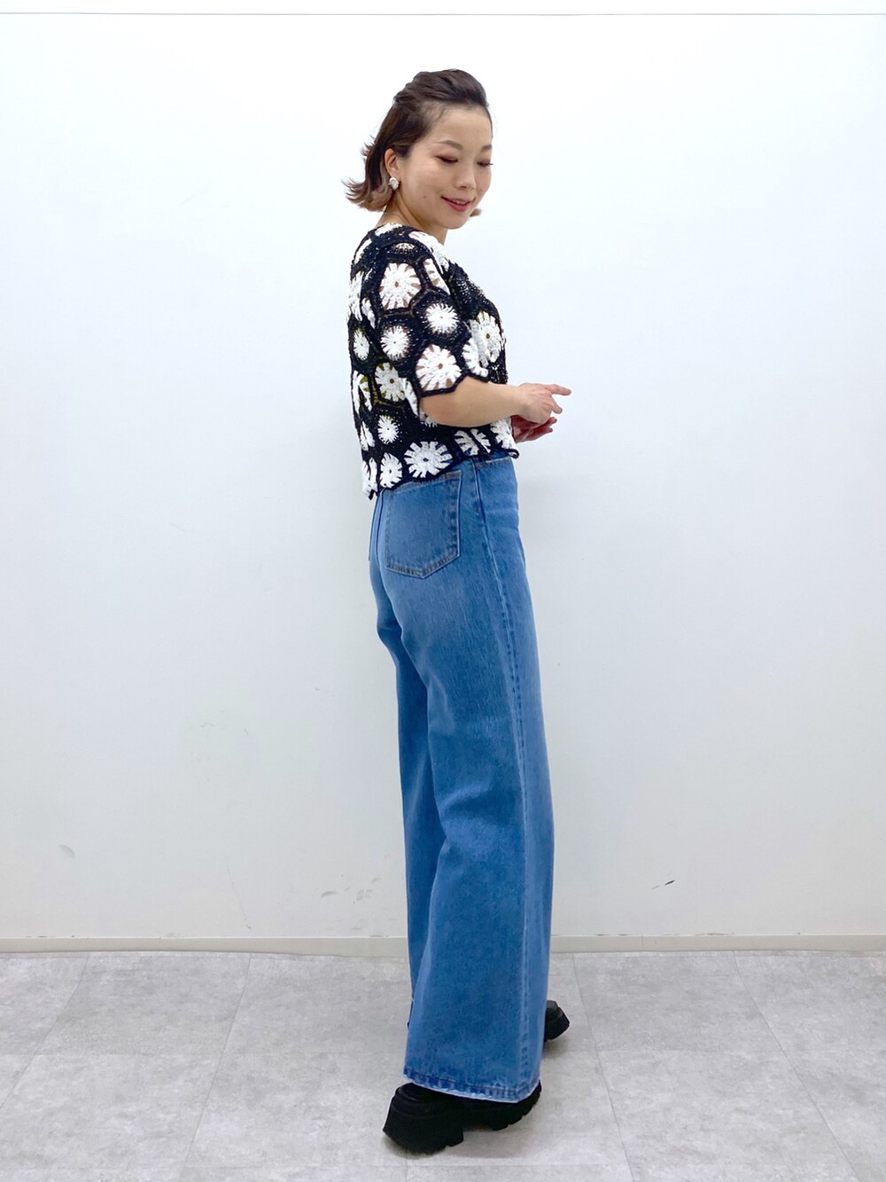 ブラック系のサンダル、イエロー系のタンクトップ、ブルー系のパンツを着用したレディースの夏コーディネートの2枚目の写真