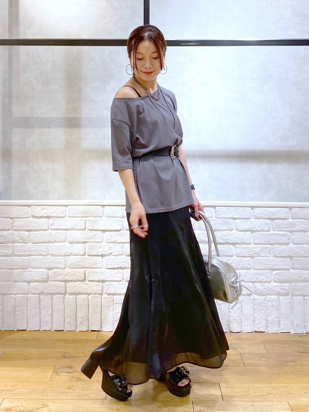 ブラック系のブーツ、シルバー系のショルダーバッグ、グレー系のTシャツ/カットソーを着用したレディースの夏コーディネートの8枚目の写真