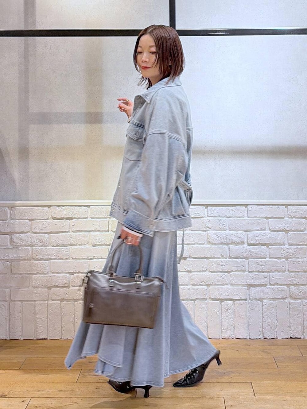 ブルー系のブルゾン、グレー系のショルダーバッグ、ホワイト系のニット/セーターを着用したレディースの春コーディネートの5枚目の写真