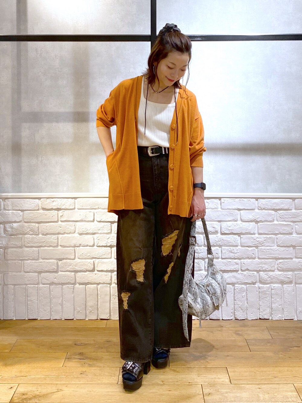 ホワイト系のタンクトップ、オレンジ系のカーディガン/ボレロ、ブラック系のデニムパンツを着用したレディースの春コーディネートの8枚目の写真