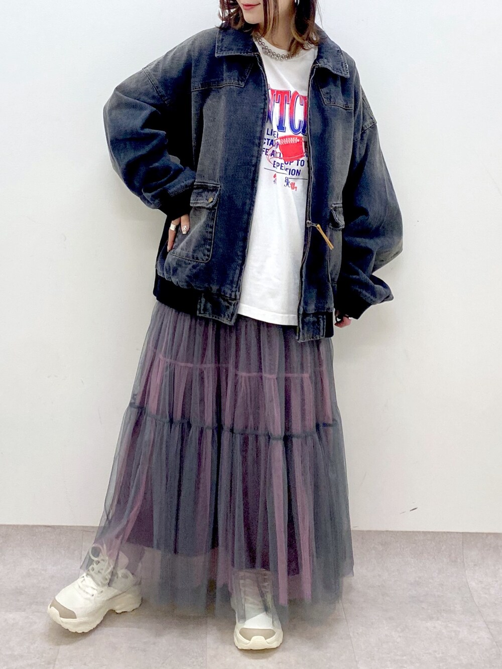 ホワイト系のTシャツ/カットソー、ブラック系のデニムジャケット、グレー系のスカートを着用したレディースの冬コーディネートの3枚目の写真