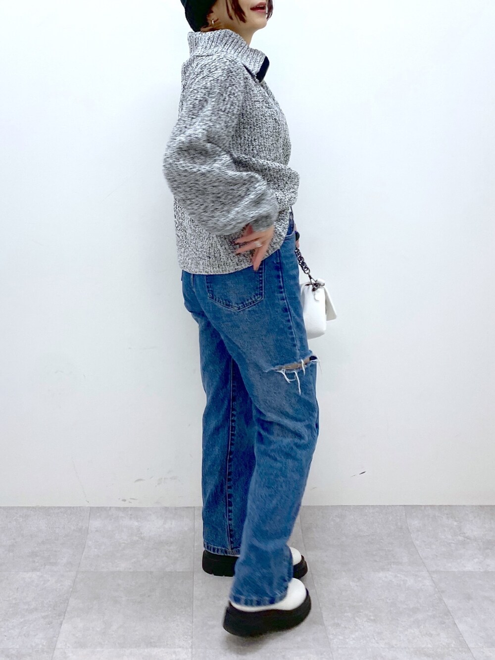 ホワイト系のバッグ、ブルー系のデニムパンツ、ホワイト系のシューズを着用したレディースの秋コーディネートの4枚目の写真