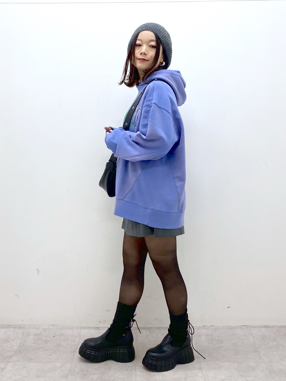 ブルー系のパーカー、ブラック系のショルダーバッグ、グレー系のその他パンツを着用したレディースの冬コーディネートの4枚目の写真