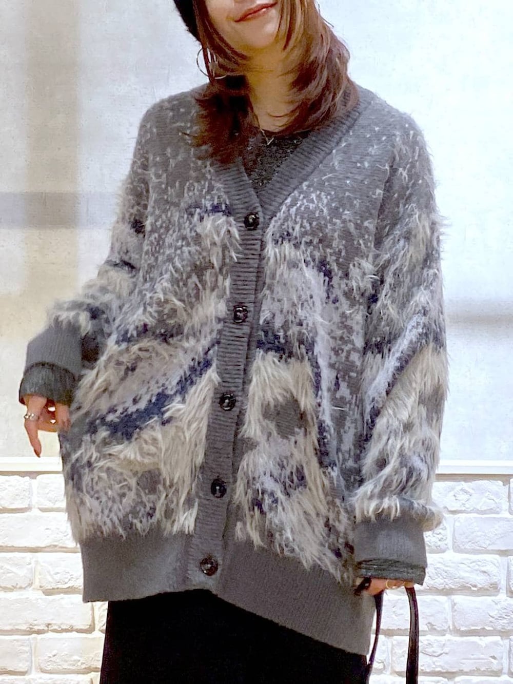 シルバー系のTシャツ/カットソー、ブラック系のブーツ、ブラック系のスカートを着用したレディースの冬コーディネートの2枚目の写真