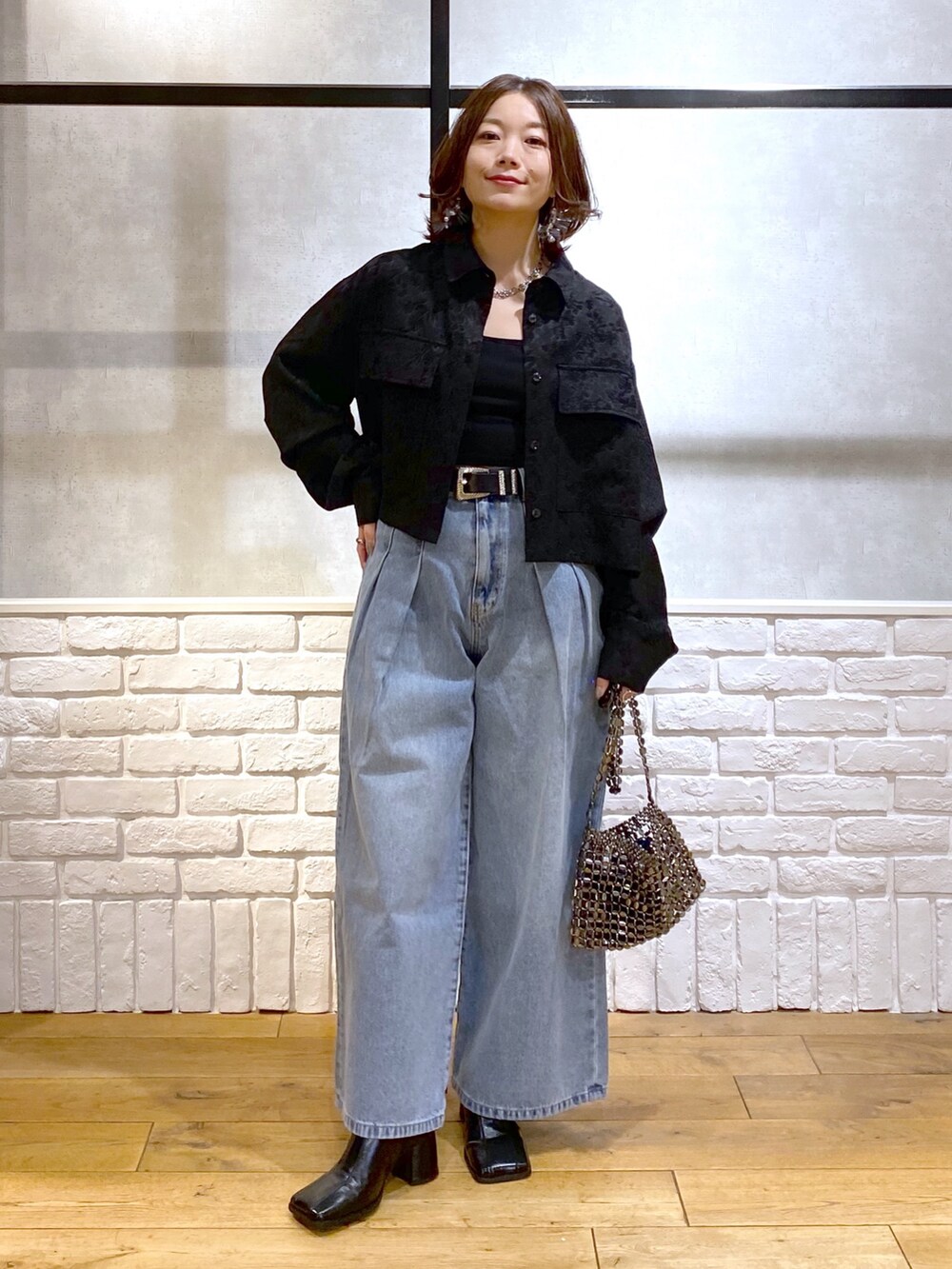 ブラック系のシャツ/ブラウス、ブルー系のデニムパンツ、ブルー系のショルダーバッグを着用したレディースの冬コーディネートの9枚目の写真