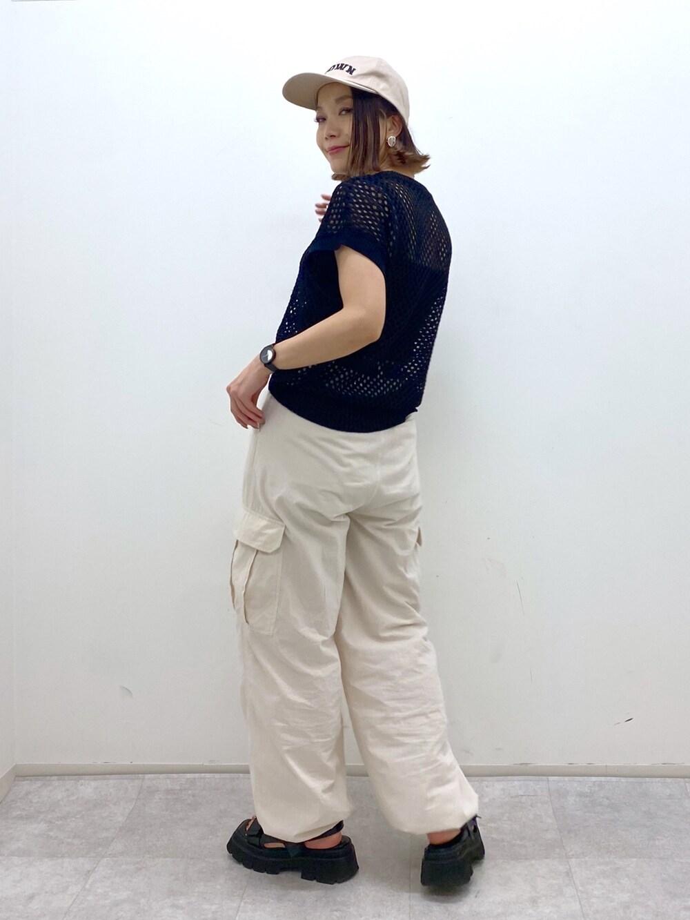 ホワイト系のカーゴパンツ、ブラック系のトップス、ブラック系のサンダルを着用したレディースの夏コーディネートの2枚目の写真