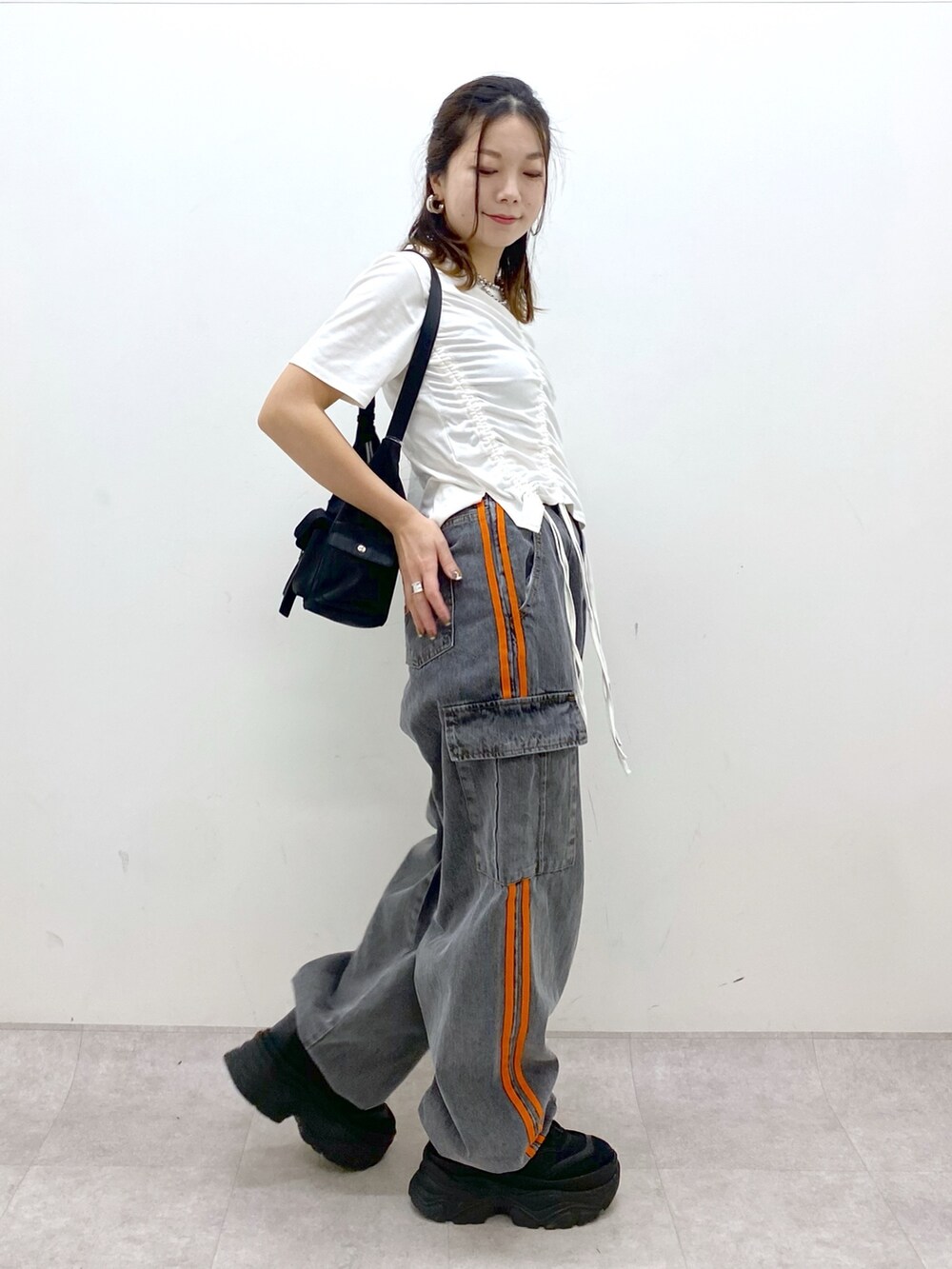 ホワイト系のTシャツ/カットソー、ブラック系のデニムパンツ、ブラック系のスニーカーを着用したレディースの春コーディネートの7枚目の写真