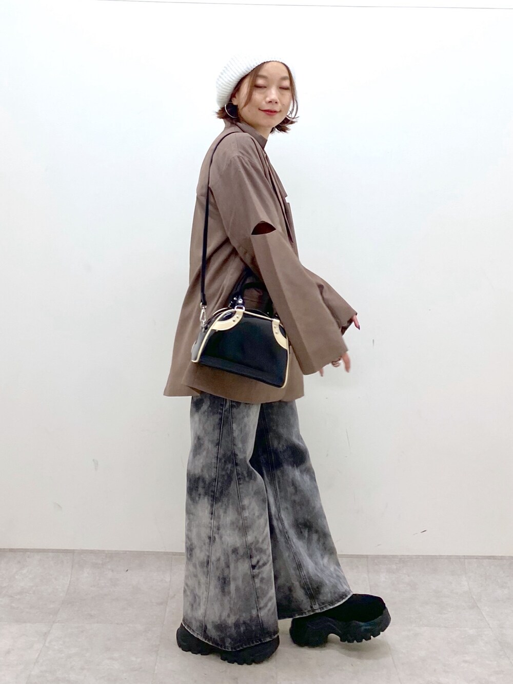 ブラック系のデニムパンツ、ブラック系のスニーカー、ブラウン系のテーラードジャケットを着用したレディースの秋コーディネートの7枚目の写真