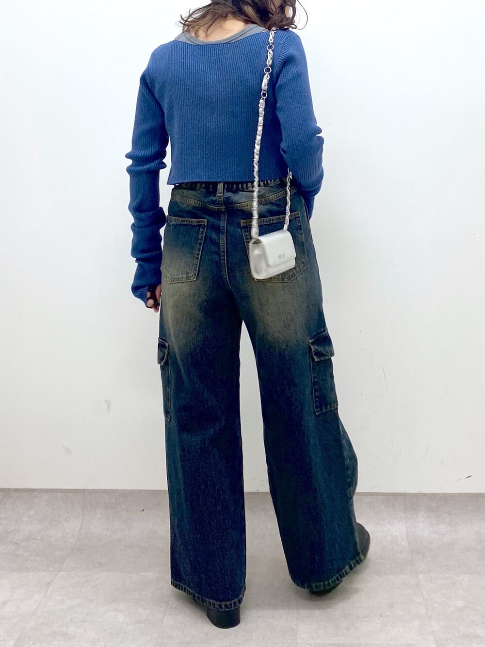 ブルー系のデニムパンツ、ブルー系のニット/セーター、ブラック系のブーツを着用したレディースの冬コーディネートの7枚目の写真