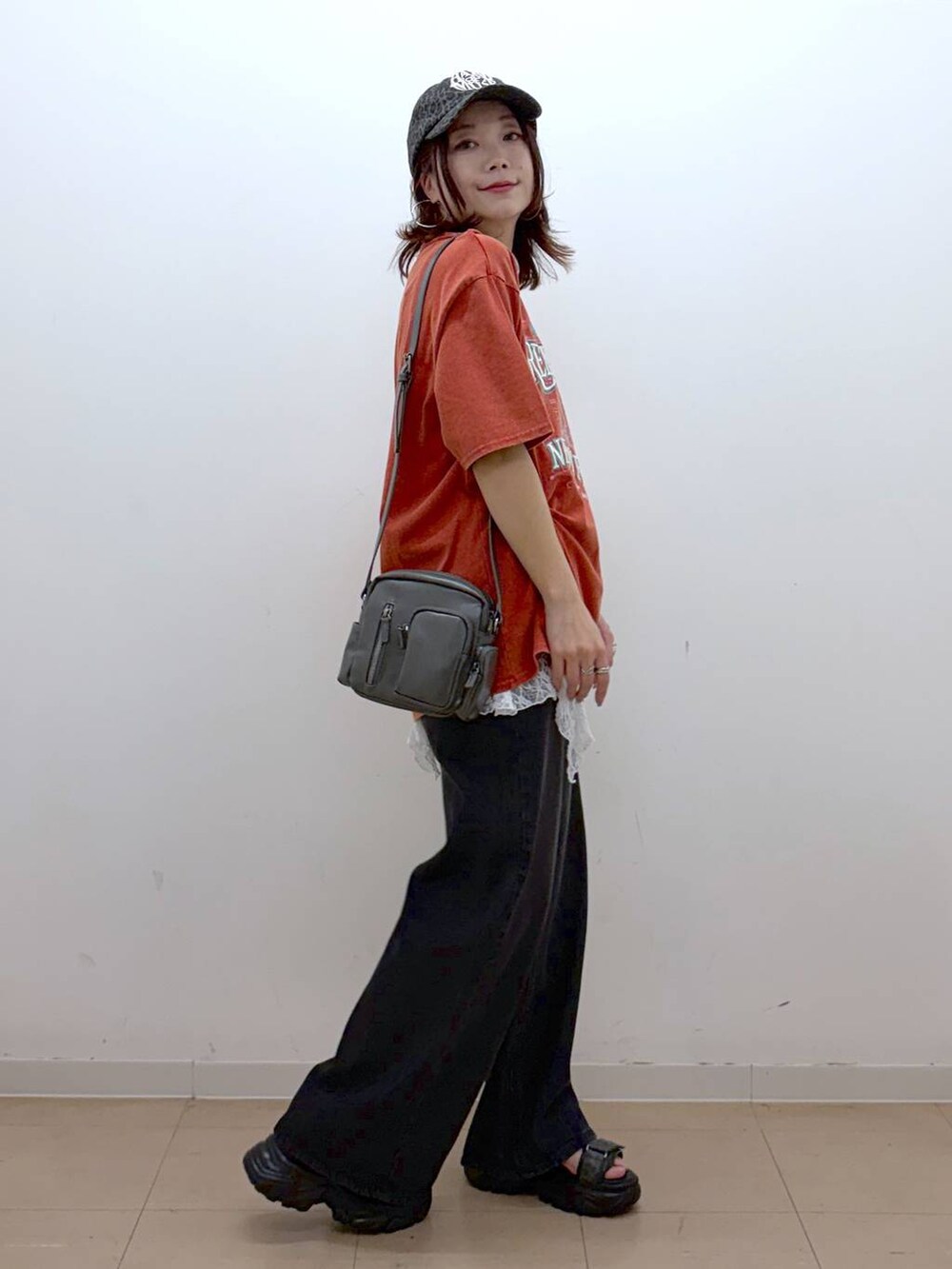 ブラック系のデニムパンツ、グレー系のショルダーバッグ、グレー系のサンダルを着用したレディースの春コーディネートの5枚目の写真