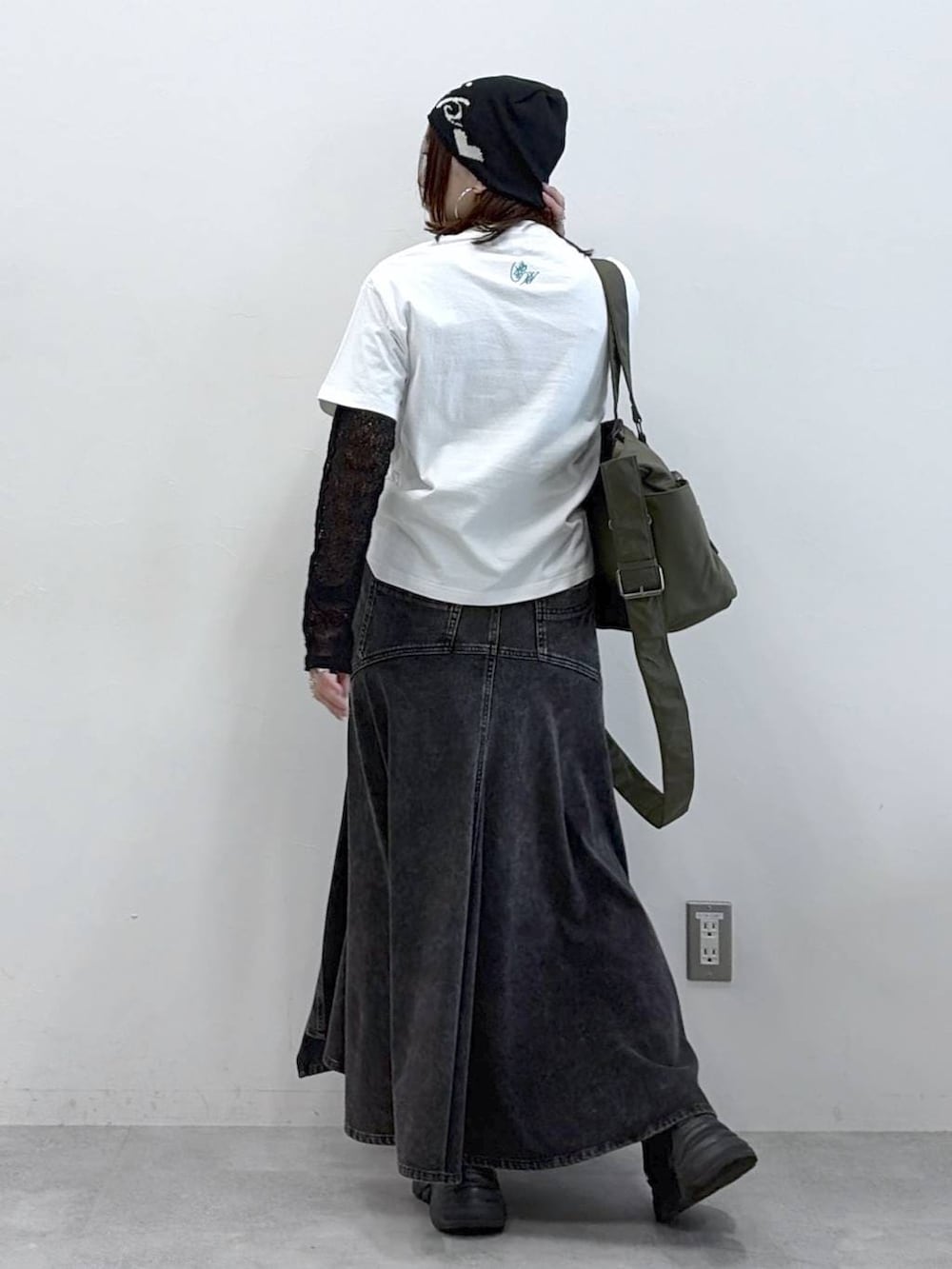 ブラック系のスニーカー、グリーン系のボストンバッグ、ブラック系のデニムスカートを着用したレディースの春コーディネートの5枚目の写真