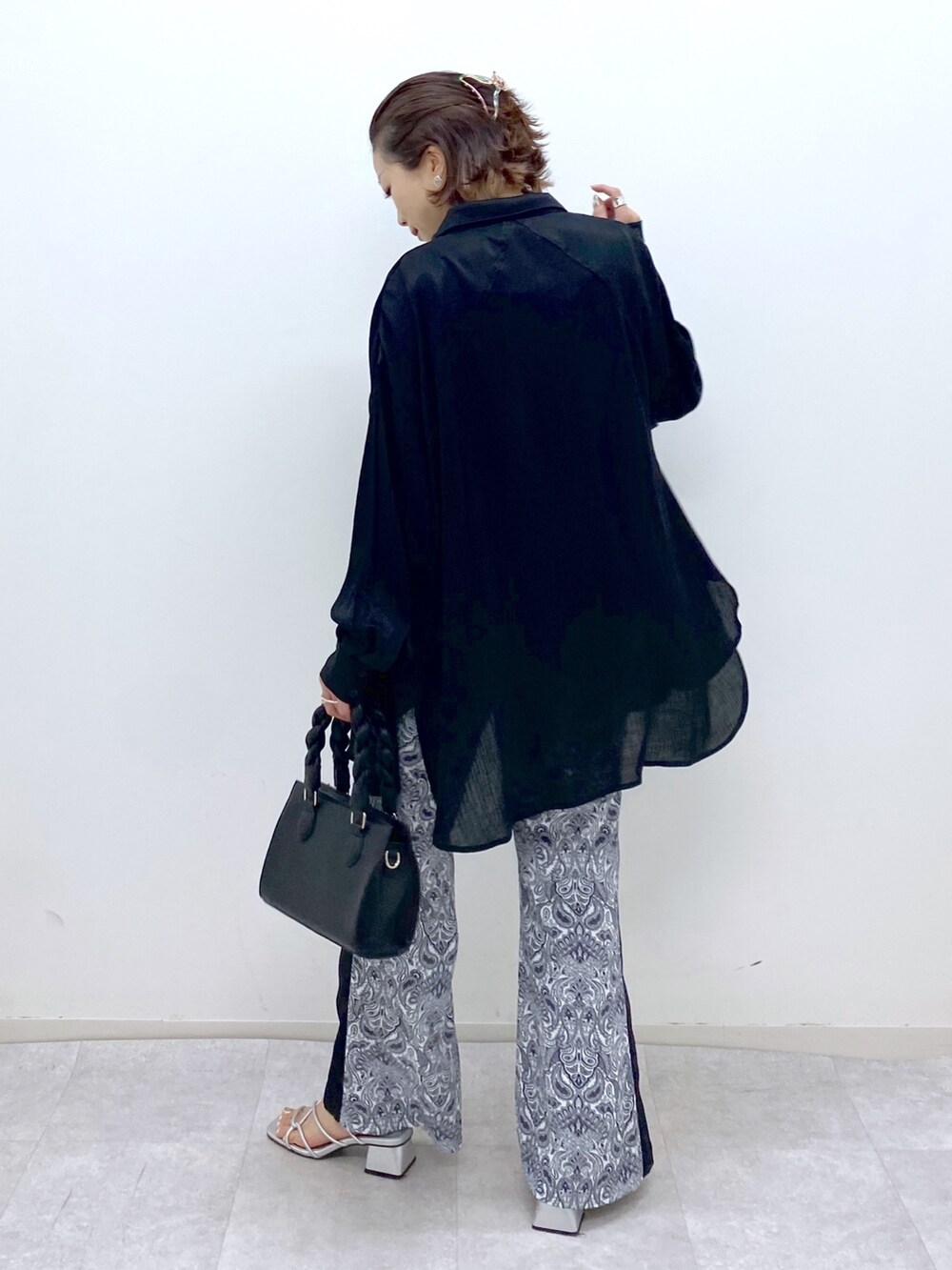 ブラック系のトップス、ホワイト系のその他パンツ、シルバー系のサンダルを着用したレディースの夏コーディネートの2枚目の写真